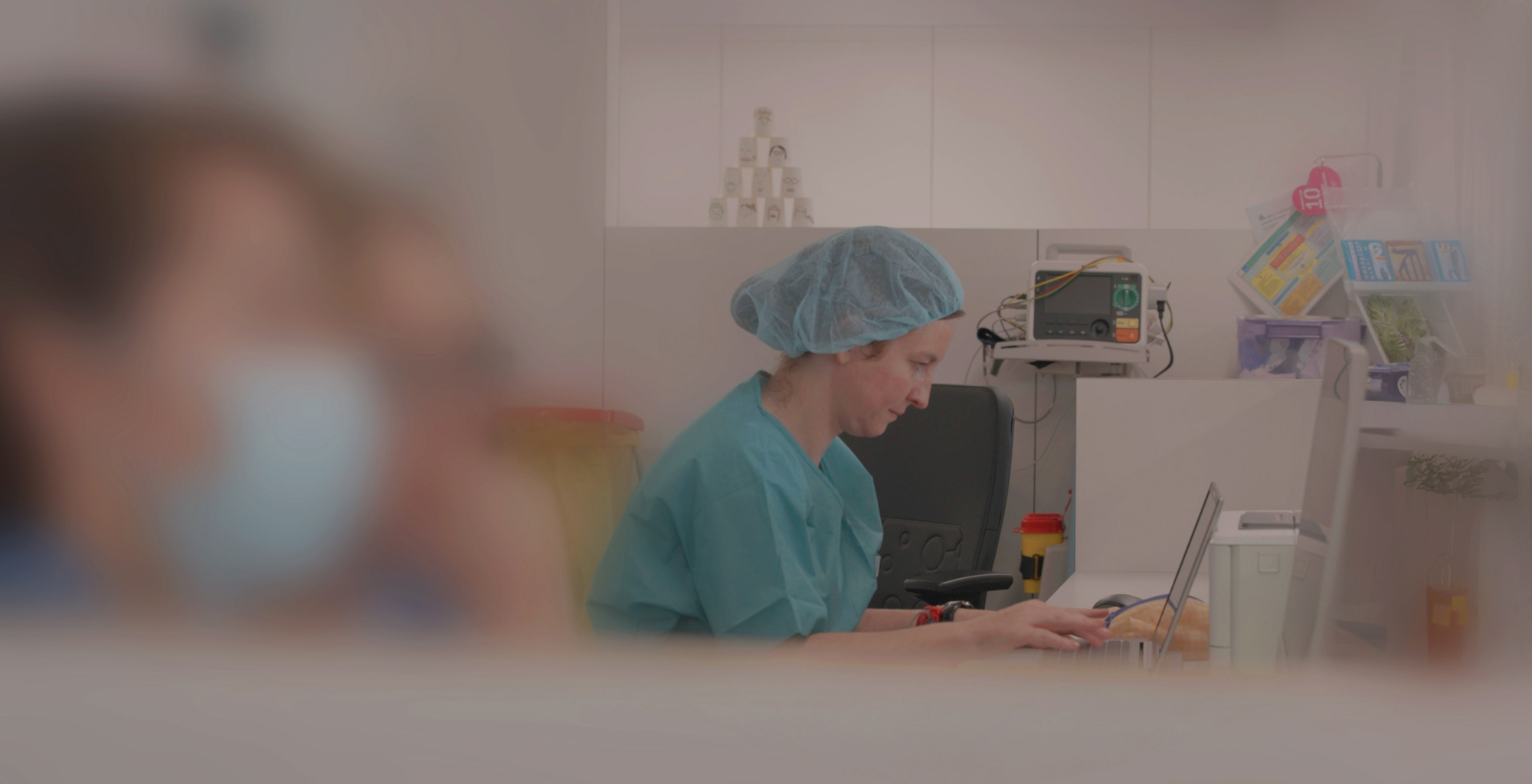 Imagen de cabecera de Telefónica Tech con varios profesionales sanitarios caminando por un pasillo acristalado de hospital moderno y luminoso.