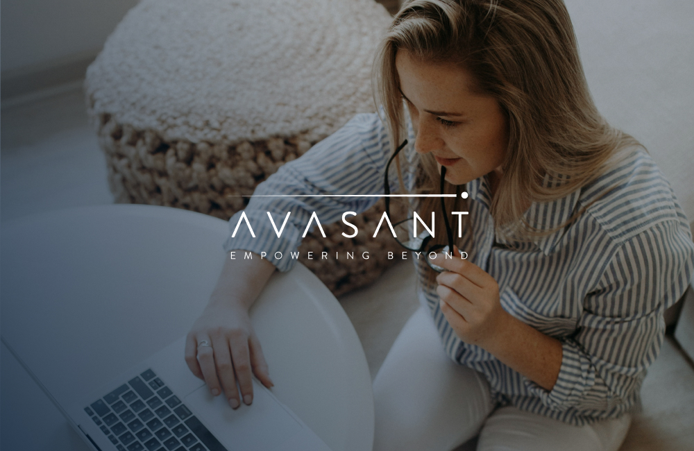 Persona trabajando con un ordenador portátil mientras sostiene unas gafas, con el logotipo de Avasant sobre la imagen.