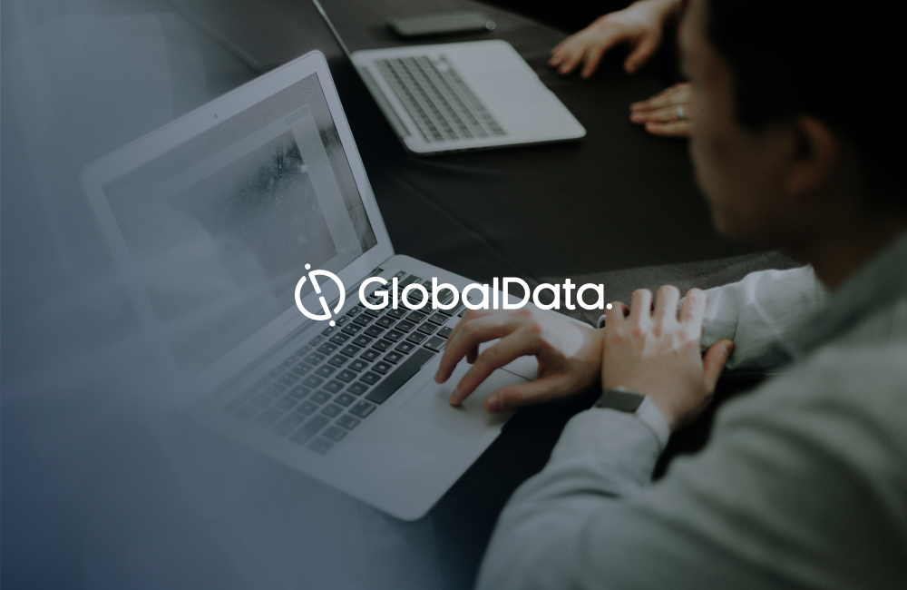 Fondo de analistas trabajando con ordenadores y logo de GlobalData.