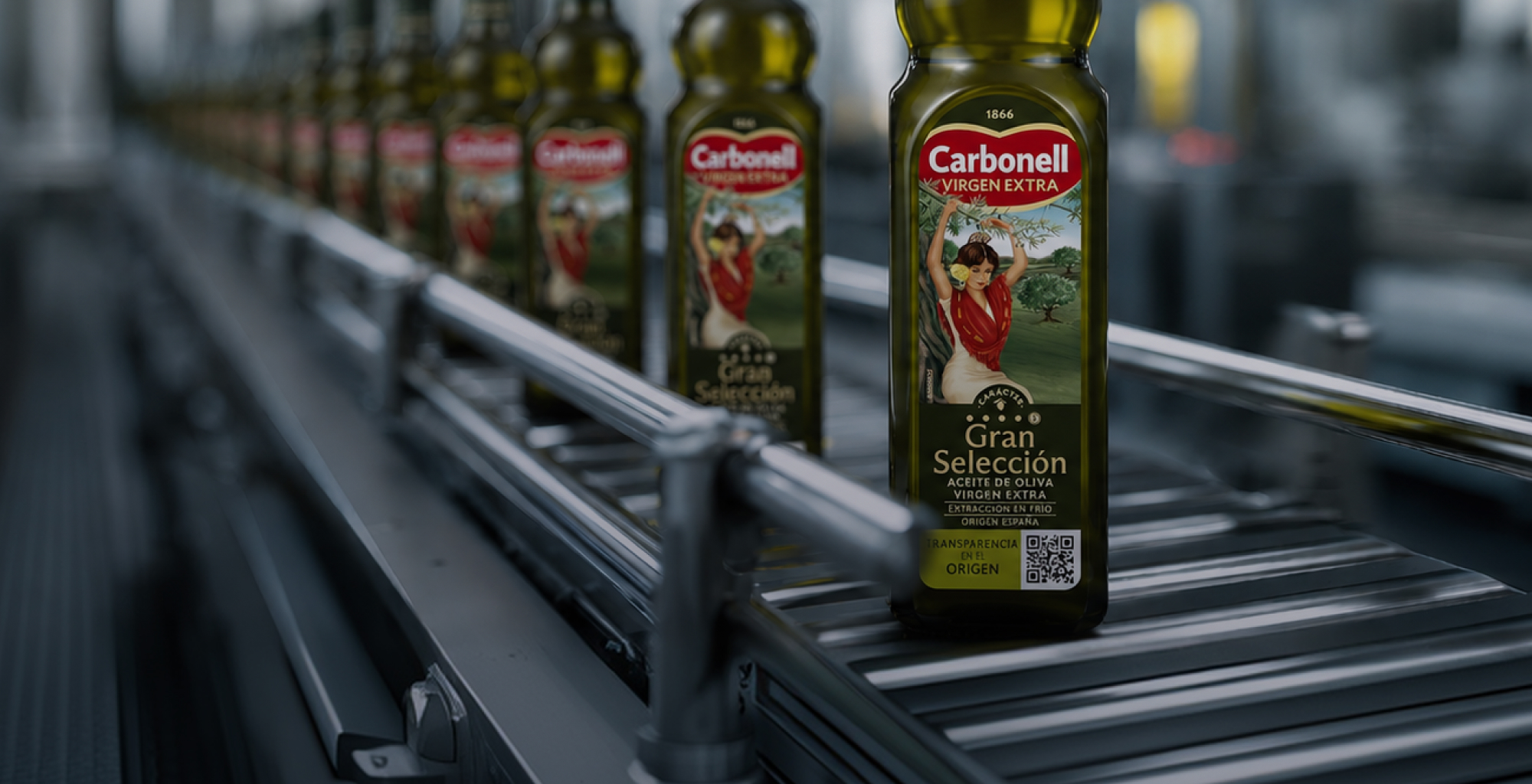 Imagen de Telefónica Tech con botellas de aceite de oliva Carbonell en una línea de producción industrial, mostrando un código QR para garantizar la trazabilidad del producto mediante Blockchain.